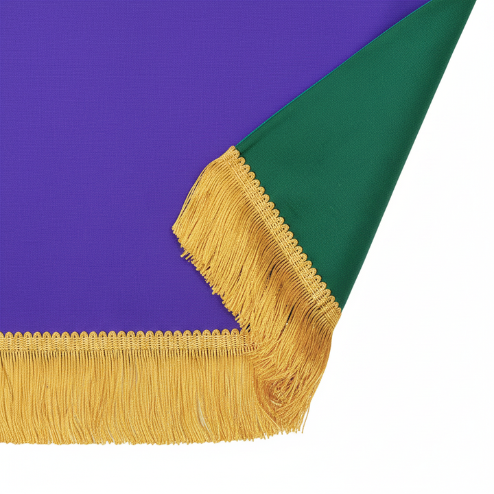 Close-up detail showing reversible edge of church pulpit cloth with green and purple double-sided design and gold fringe, white background