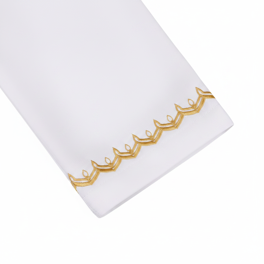 Close-up detail of white thobe sleeve cuff showing ornate gold embroidery trim band at wrist, white background