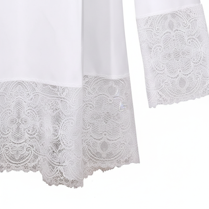 Close-up detail of Style D alb robe showing wide white floral lace hem border and cuff lace trim, white background
