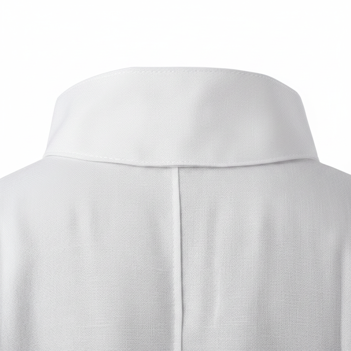 Close-up detail of white alb robe showing high stand collar construction and center back seam, white background