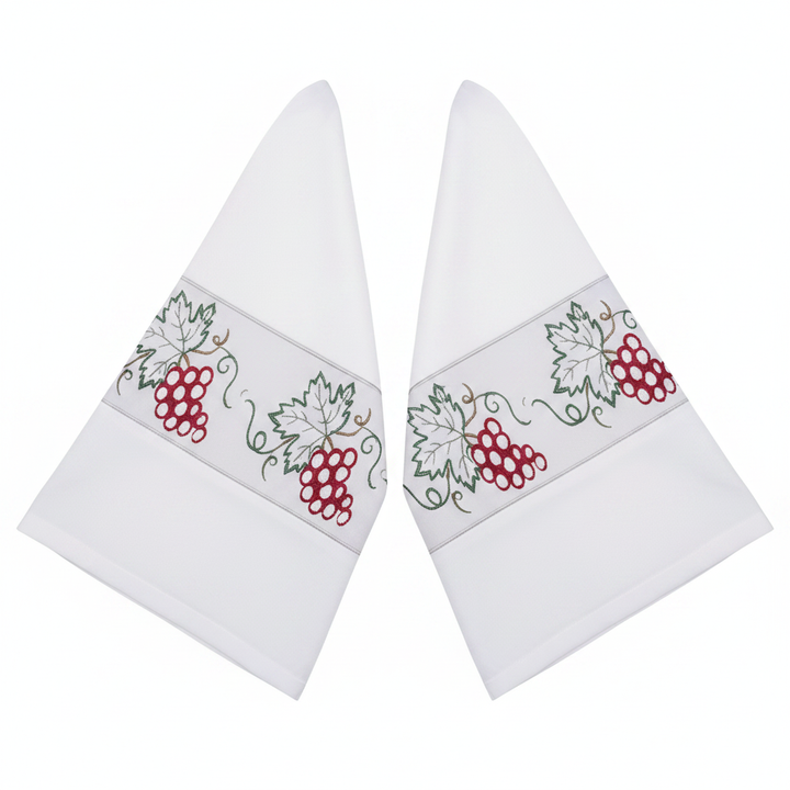 Close-up detail of white clergy alb robe showing both wide bell sleeve cuffs with grape vine embroidery band, white background