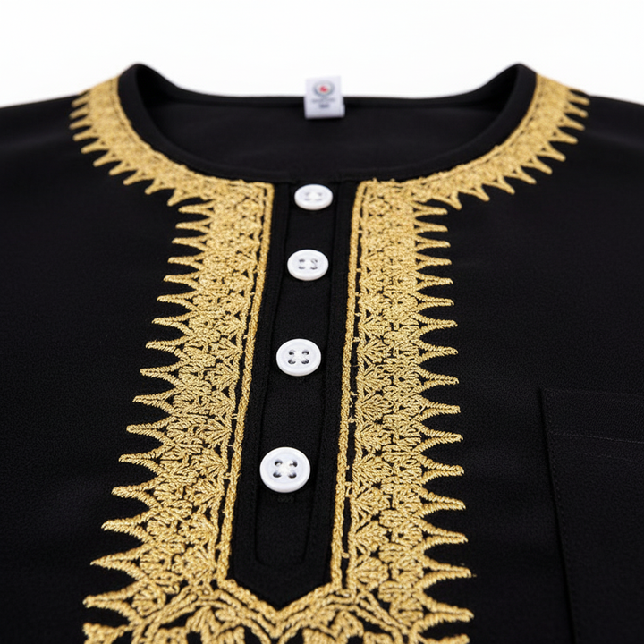 Close-up detail of black thobe neckline showing elaborate gold U-shape embroidery pattern and decorative white buttons on placket, white background