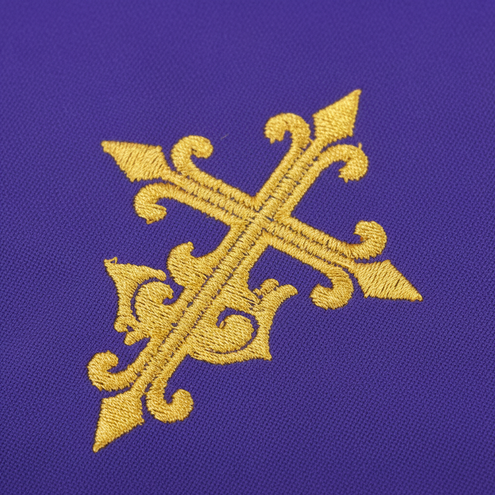 Close-up detail of purple liturgical pulpit stole showing embroidered gold ornate cross and gold fringe tassel, white background
