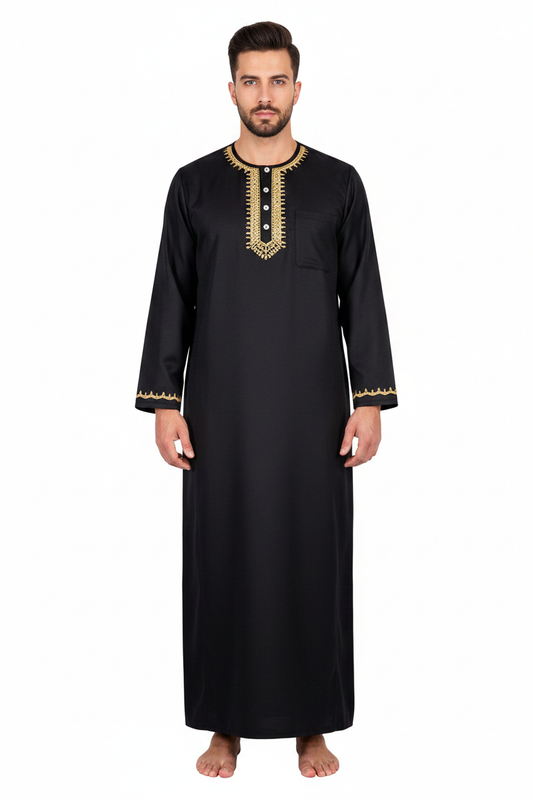 Male model wearing black Islamic thobe jubba with gold U-shape neckline embroidery and button placket, full body front view, white background