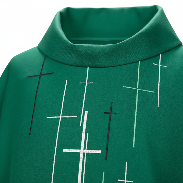 Close-up detail of green chasuble vestment showing scattered white cross print pattern and stand collar, white background
