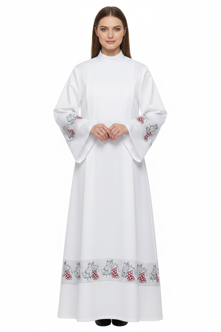 Female model wearing white clergy alb robe with grape vine embroidery cuffs and hem, full body front view, white background