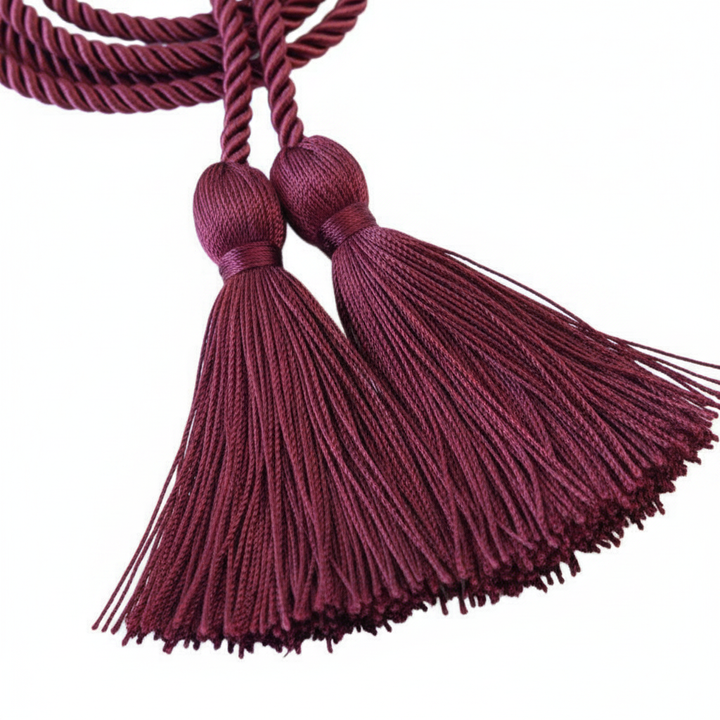 Close-up macro detail of maroon honor cord showing twisted polyester braid texture and bulb tassel construction