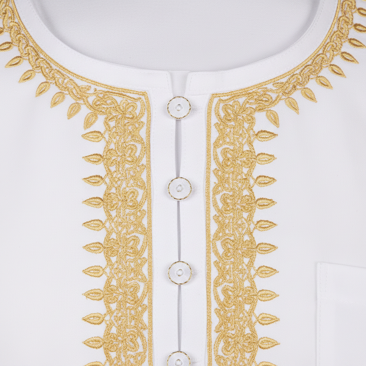 Close-up detail of white thobe neckline showing elaborate gold U-shape embroidery pattern and decorative buttons on placket, white background