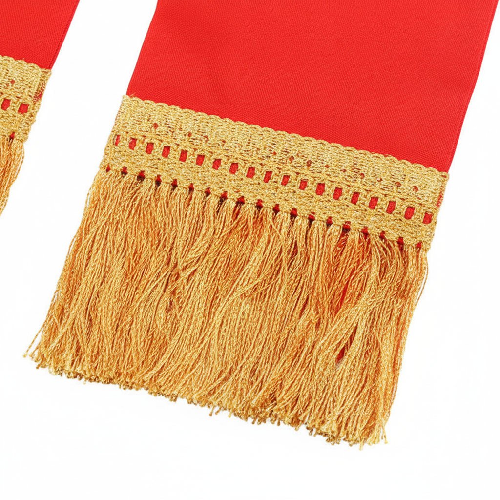 Close-up detail of clergy stole end showing gold fringe tassel trim and gold flame embroidery on red fabric, white background