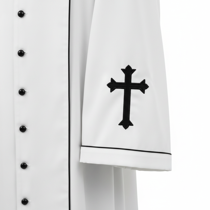 Close-up detail of white clergy cassock robe cuff with black cross embroidery and black piping trim