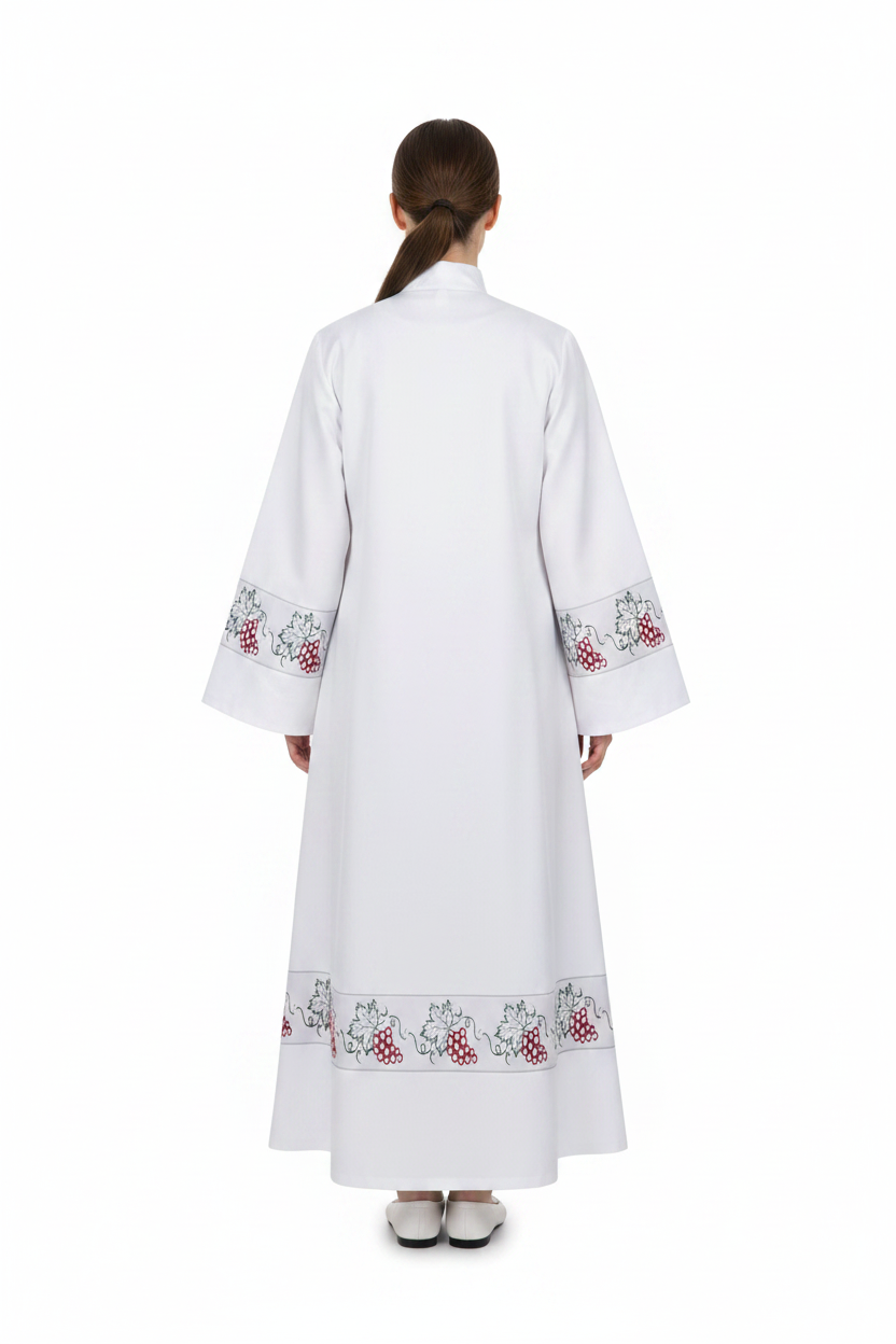 Female model wearing white clergy alb robe with grape vine embroidery cuffs and hem, full body back view, white background