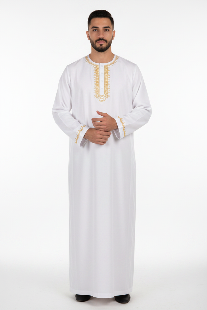 Male model wearing white Islamic thobe jubba with gold U-shape neckline embroidery and button placket, full body front view, white background